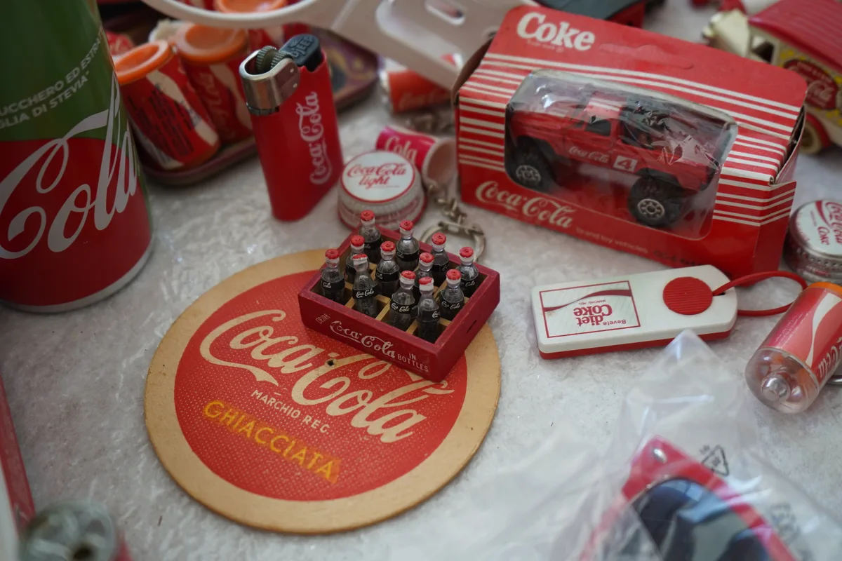 Man sieht Daniel Jaussi und seine Coca-Cola Sammlung.